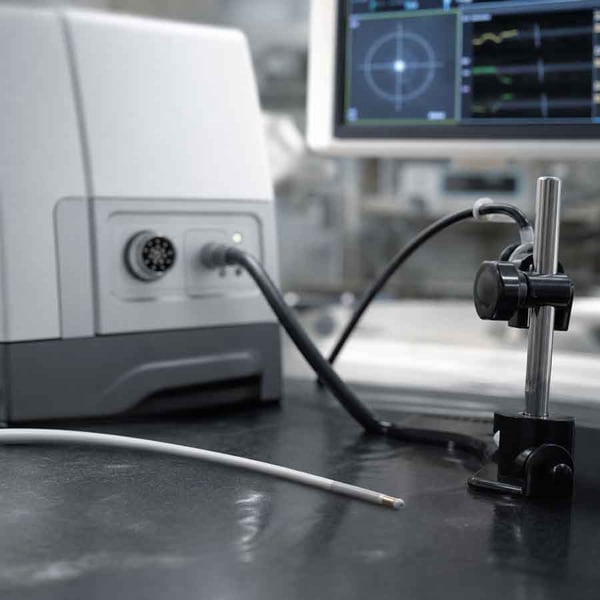An EM sensor connects the miniature coil to the wider field-generation, signal-processing, and navigation system.